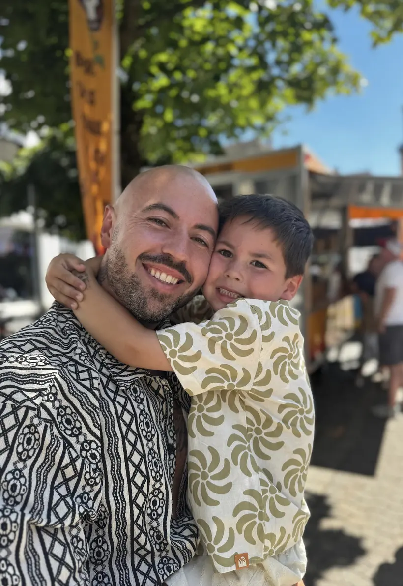 Adrian mit seinem Sohn im Arm, beide lachen