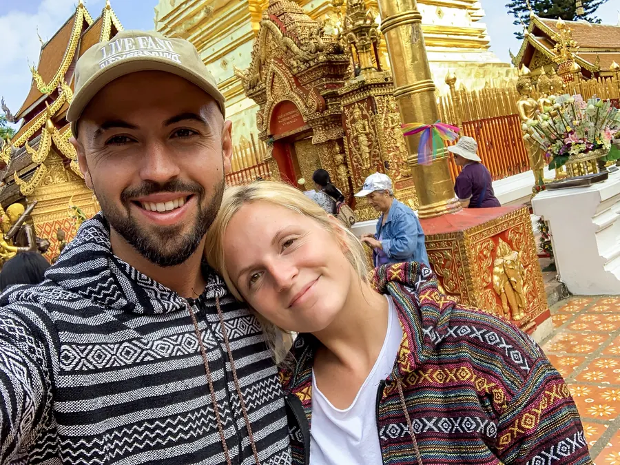 Selfie von Adrian mit seiner Schwester vor einem goldenen Tempel in Thailand